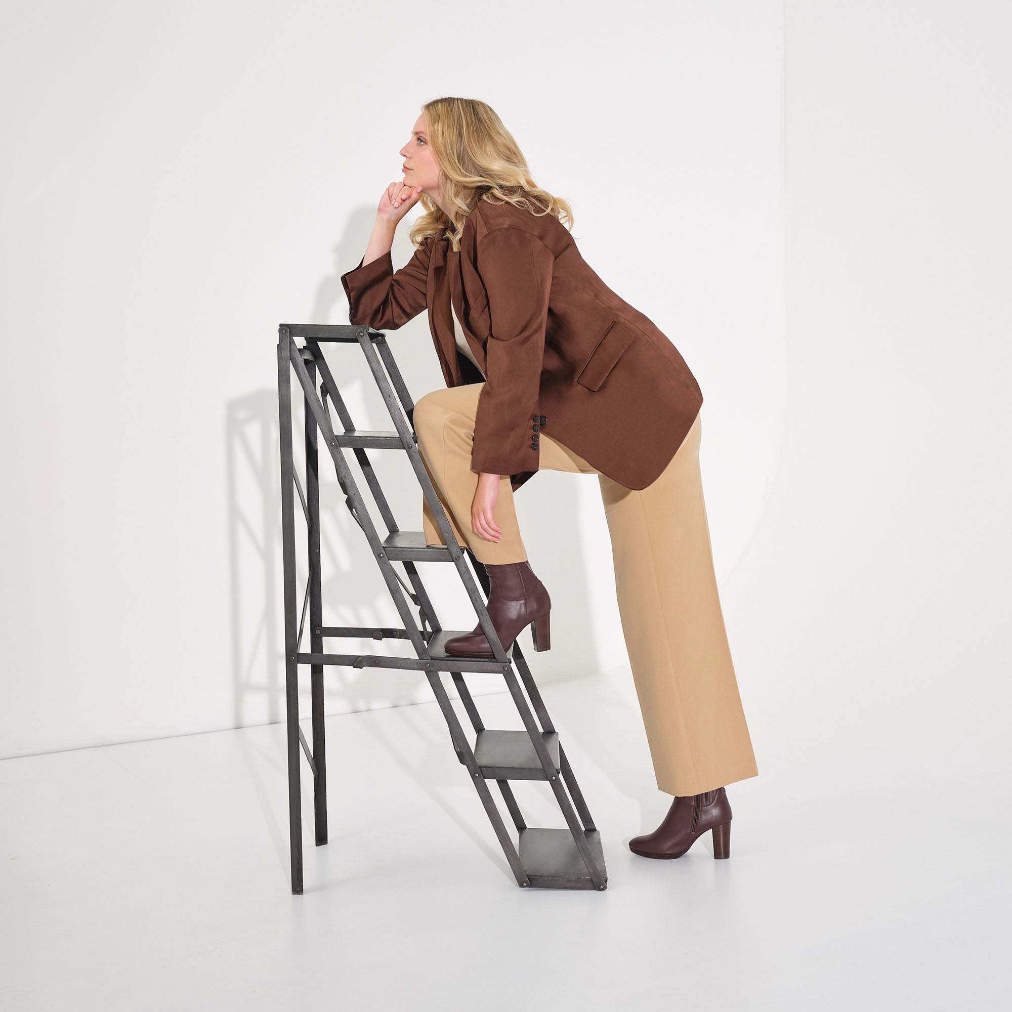 woman standing on a ladder wearing burgundy leather narrow calf boots