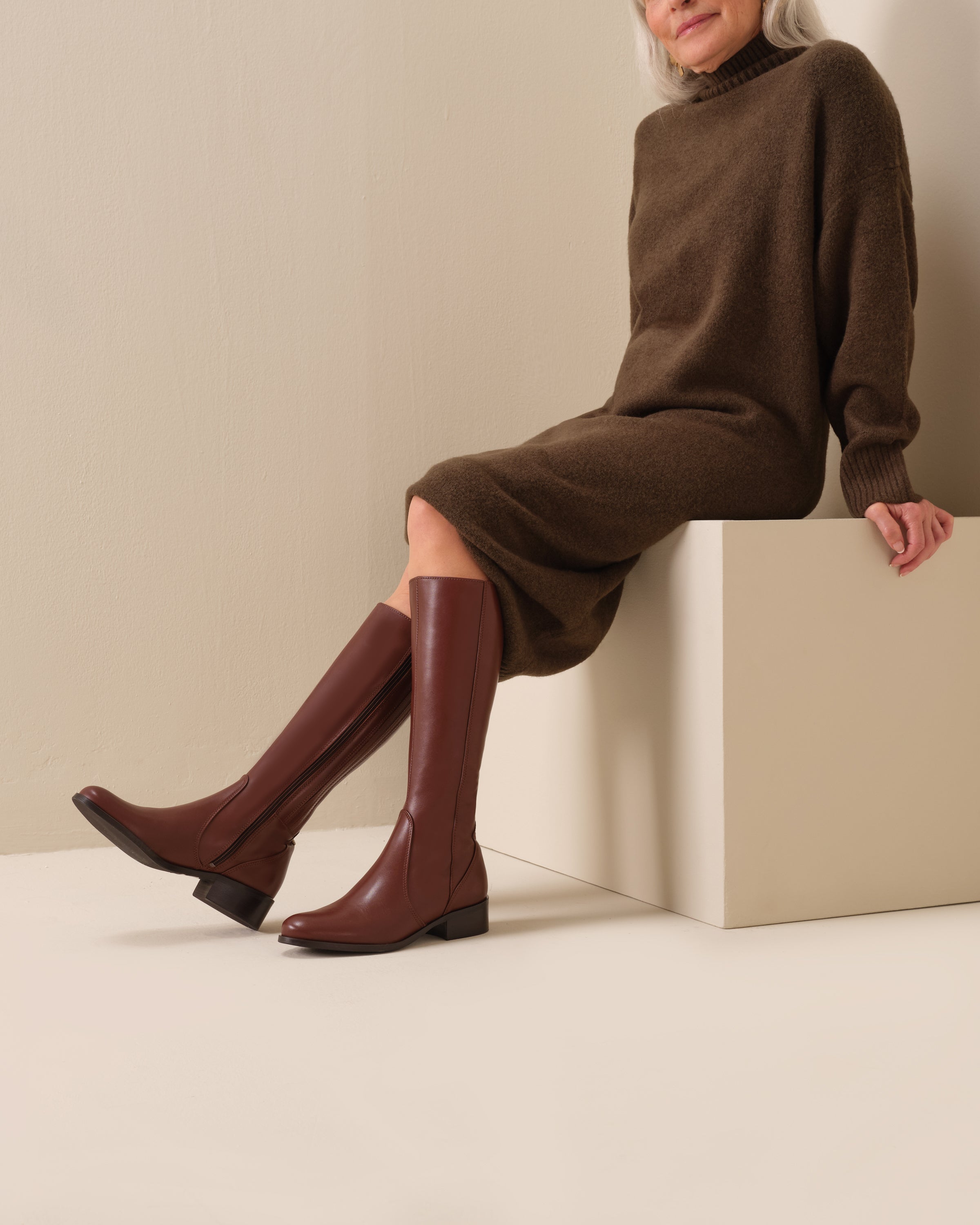 woman wearing knee high brown leather flat boots