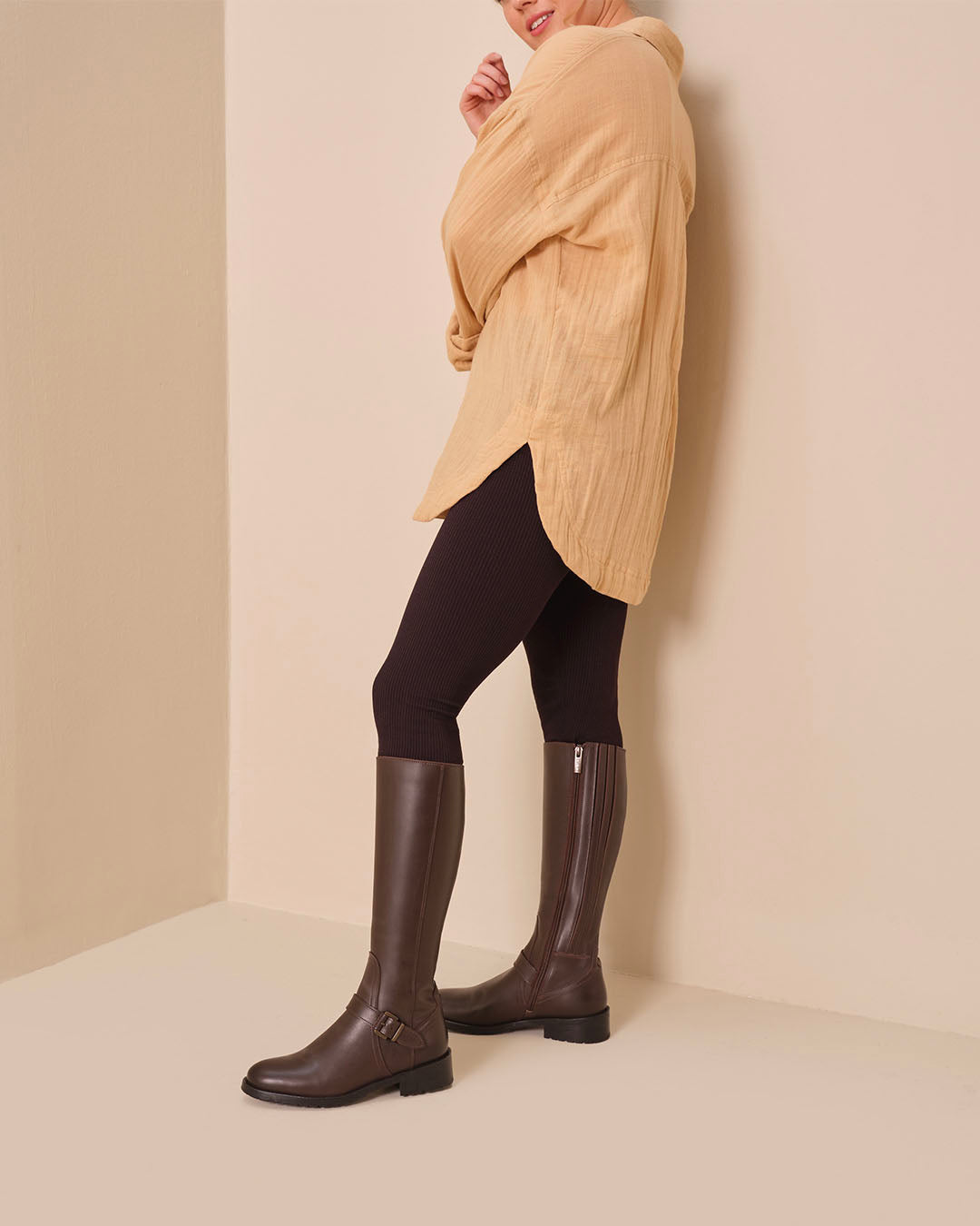woman wearing dark brown leather flat boots with buckles