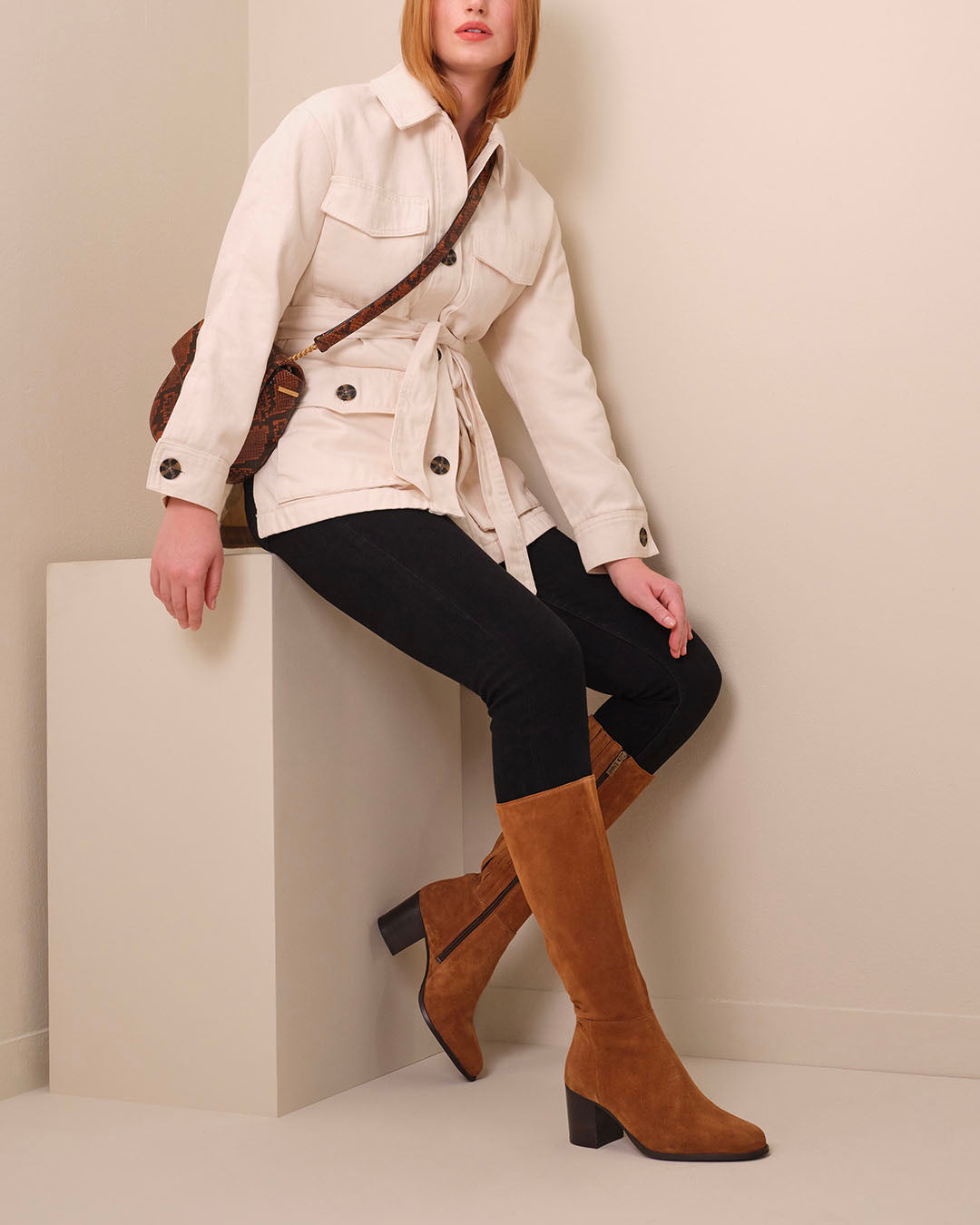 woman wearing knee high tan suede heeled boots