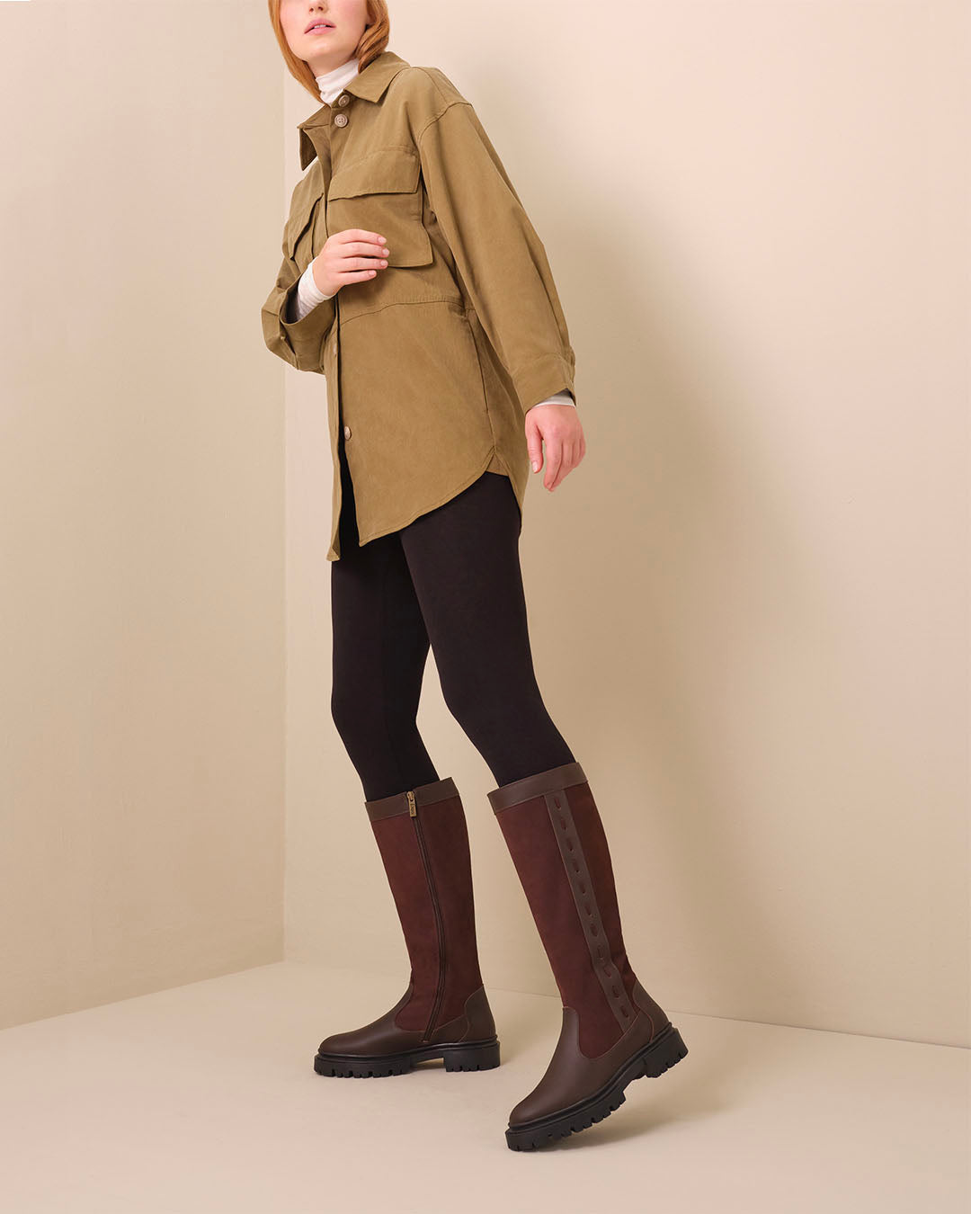 woman wearing knee high narrow calf dark brown leather and suede flat boots
